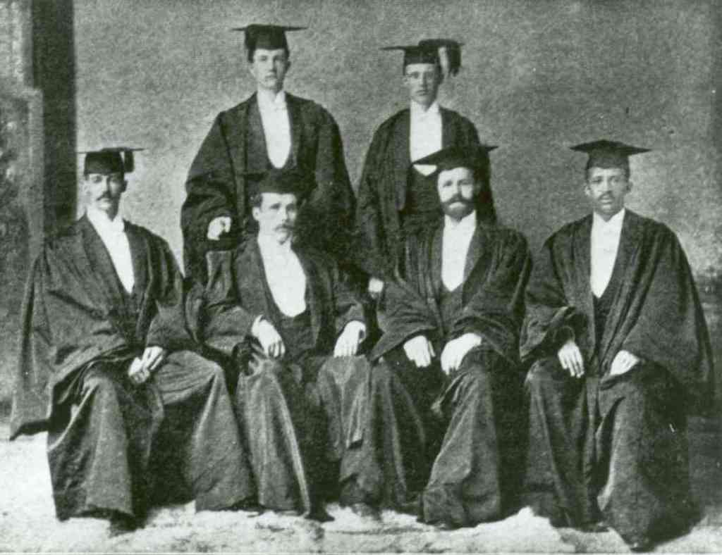 A black and white photos of 6 people in cap and gown