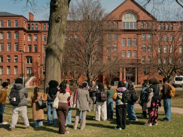 A group of people gathered outside of a brick building museum