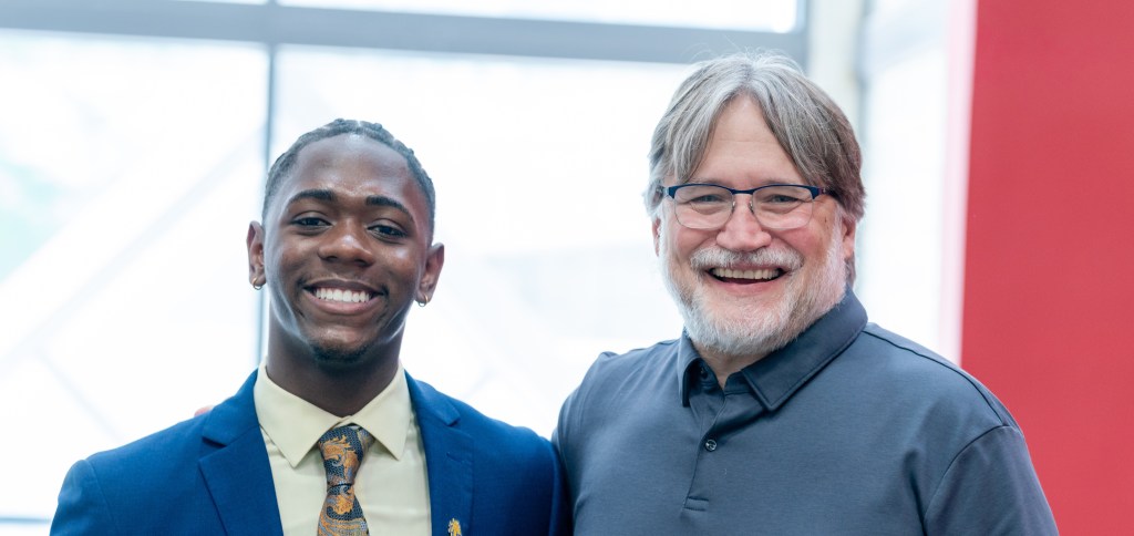 Two people, Derrick Bradley and Gary Adamkiewicz, posing for a photo side by side, smiling.